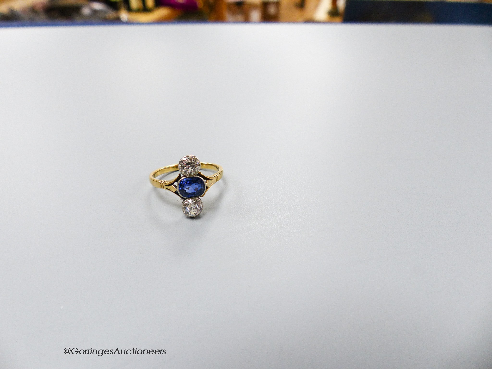 A, 18ct, two stone diamond and single stone sapphire set upfinger ring, size M, gross 2.9 grams